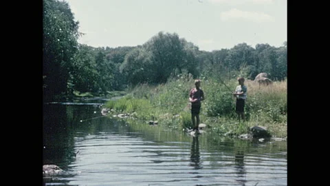 1960s: man holding up fish and smiling, two boys fishing then putting down rods Stock Footage