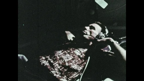 1960s: Man inside simulator talks and touches knobs. Men working outside lunar 스톡 동영상 100302770