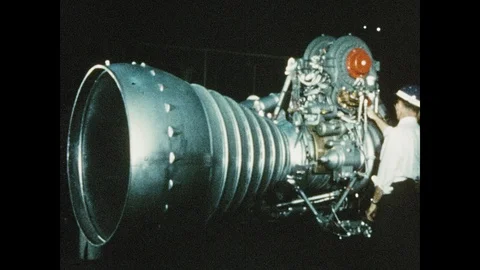 1960s: Man inspecting rocket engine. Rocket firing at launch site. Stock Footage 100642982