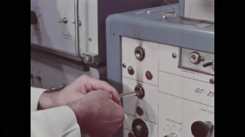 1960s: Man in lab inserts test sample into machine, checks polygraph readout for Stock Footage 212809123