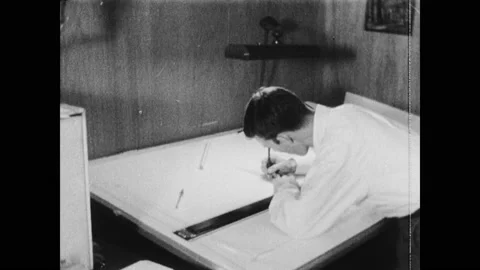 1960s: Man leans over drafting table, draws. Woman pulls blueprint from machine. Stock Footage