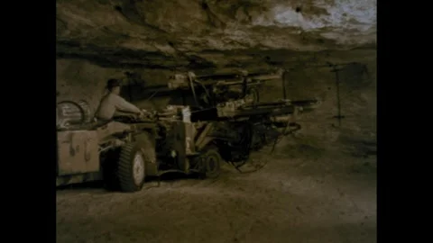 1960s: Man operates mobile mining machine in underground mine. Stock Footage 248246384