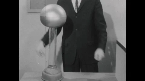 1960s: Man places electrostatic generator on counter and turns it on. Man places Stock Footage 255868167