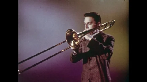 1960s: Man Plays Brass Slide Bone Trombone Stock Footage 74723053
