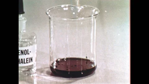 1960s: Man pulls liquid into dropper, drops liquid into large beaker filled with Stock Footage 92100417