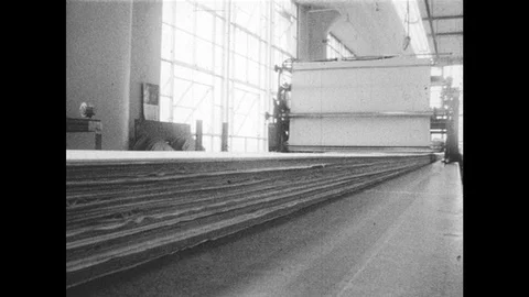 1960s: Man runs machine over fabric. Man lays stencil over fabric. Stock Footage 98008583