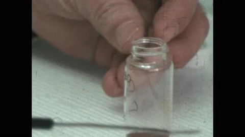 1960s: Man shakes out tiny tube. Man scoops substance from vial, places into Stock Footage 172029562