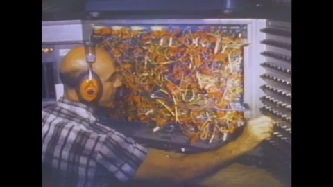 1960s: Man sits at console, adjusts knobs and dials. Flaps on plane wing move up 스톡 동영상 84806782