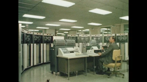 1960s: Man sits in front of early computer. Rocket explodes out of ocean. Checks Stock Footage