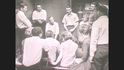 1960s: Man Stands At Front Of Room, Addresses Group, Talks, Gestures. People Stock Footage