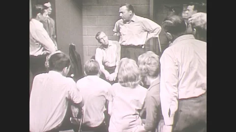 1960s: Man Stands With Hands At Waist, Addresses Group. Group Sits Still, Stock Footage