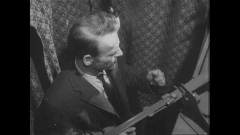 1960s: Man struggles to make a decision inside a voting booth. Man shuffles feet Vidéo 80208926