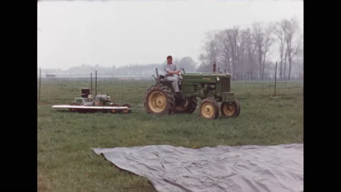 1960s: man on tractor pulling a pallet with machine that spreads sealant, men Stock Footage 132616082