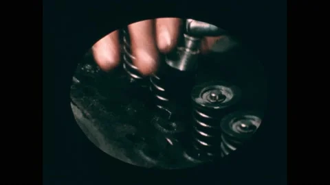 1960s: Man works on engine block, removes bolts, hits block with mallet. Man Stock Footage 195118748