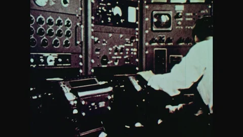 1960s: Man works at large computer panels. Wave form readout on monitor. Vidéo 124817267