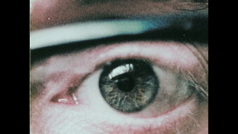 1960s: Man's eye. Printer prints graph on paper. Man sits at computer. Stock Footage 104882230