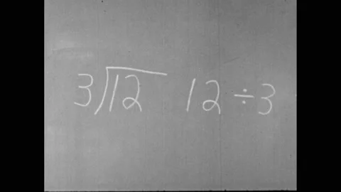1960s: Math problem on chalkboard. Boy and girl smile. Boy writes on chalkboard. Stock Footage 156431432
