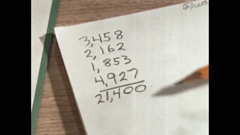 1960s: maths problem written on paper. Pencil points at numbers on paper. Stock Footage 219965655