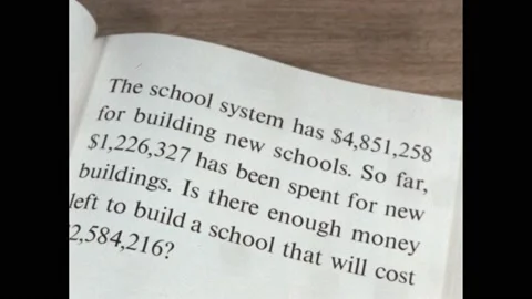 1960s: maths question about money in workbook. School system spending maths Stock Footage 219965633