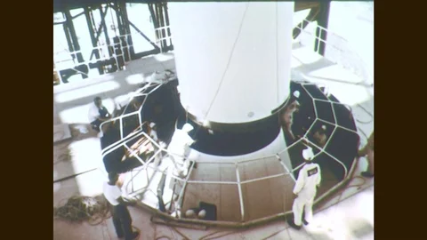 1960s: Men assemble rocket engine. Men remove cover from nose cone. Rocket nose Stock Footage 77053264