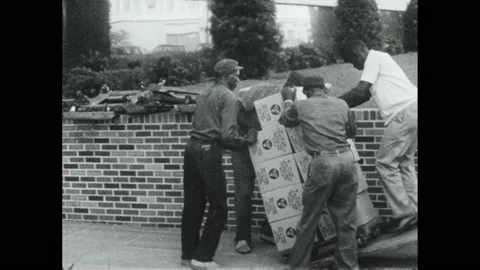 1960s: Men carry boxes down stairs. Barrels stacked up. Delivery truck outside 스톡 동영상 168386992