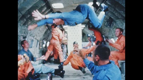 1960s: Men float in zero gravity. Man plunges into pool. Centrifuge. Man lands Video stock 101666474