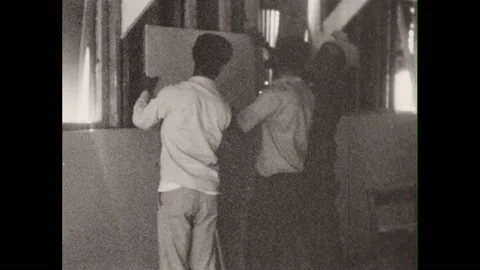 1960s: Men hold sheetrock, adjust placement, smoke. Men talk, shake hands. Girls Stock Footage 213949462