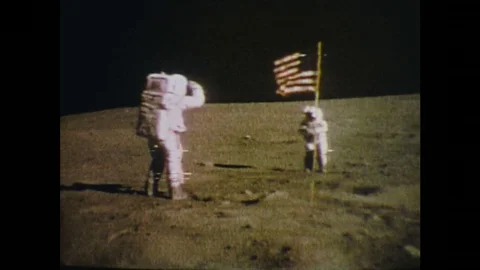 1960s: Men on moon salute USA flag. Astronauts walk on moon Stock Footage