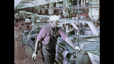 1960s: Men put windshield on car in factory. Hands insert lights into car frame. 스톡 동영상 103558828