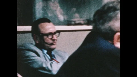1960s: Men sit around table in NASA mission control room. Men in front of 動画素材 104769174