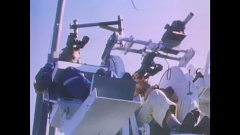 1960s: Men sit in control seat, hold onto controllers, look through binoculars. Stock Footage 84806797