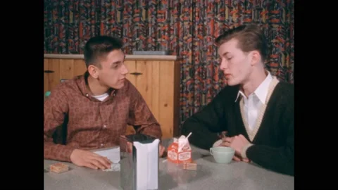 1960s: Men sitting at dining table, talking. Hand holding clapperboard. Man and Stock Footage 166467102