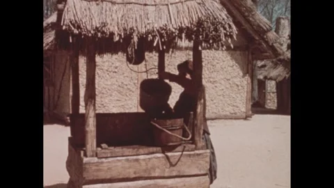 1960s: Men stacking barrels. Man getting water from well. Man building wall with Video stock 295212254