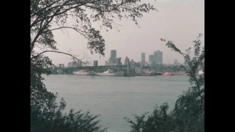 1960s: Men talking on bench, zoom in, hand holding newspaper. Long shot of city Stock Footage 303651948