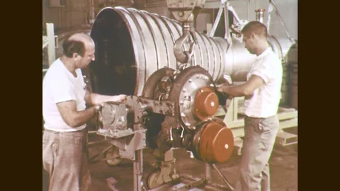 1960s: Men work on rocket engine. Men replace parts on rocket engine. Stock Footage