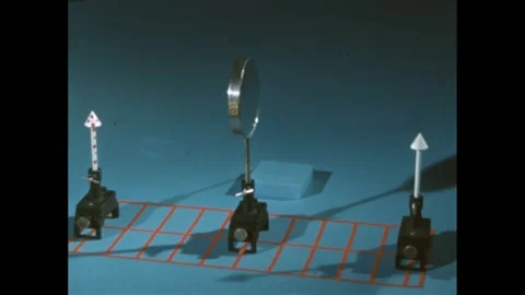1960s: Mirror between two objects on a grid, camera pans around to show Stock Footage 247158546
