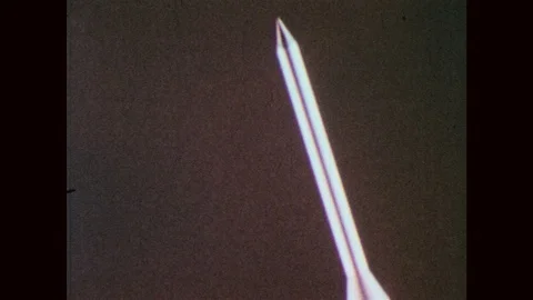 1960s: Model rocket ship flies through sky. Smoke and fire billows from rocket Stock Footage 88155175