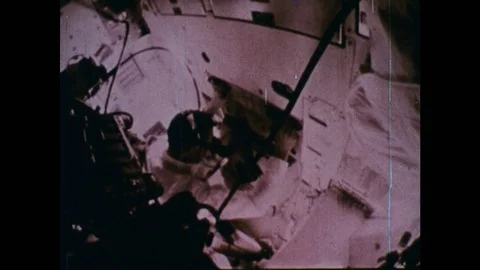 1960s: NASA astronaut working inside cabin of space rocket. Astronaut pulls 스톡 동영상 75096675
