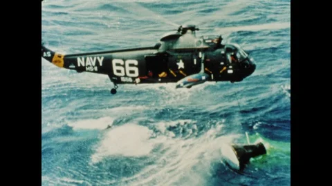 1960s: Navy divers drop inflatable raft and men into ocean near floating Gemini Stock Footage 101665740