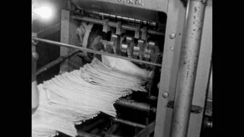 1960s: Newspapers dropping from machine. Paper running through press, rollers Stock Footage 154259733