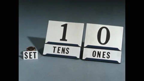 1960s: Number cards on stands, stack of pennies by cards. Writing on cards. Stock Footage 169593978