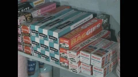 1960s: Packages of plastic wrap on shelf in grocery store. Man at check stand Stock Footage 188534593