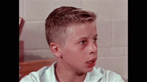1960s: Pencil points to a math problem "½+¼" Boy talks to himself. He looks Stock Footage 220378878