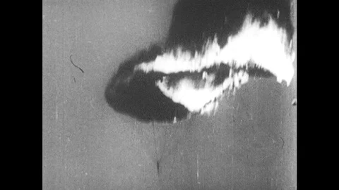 1960s: pilot floating down with burning parachute, anti-air guns firing flak, Stock Footage 121385358