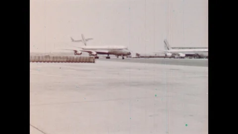 1960s: Planes sit and taxi on runway of airport. Planes sit on runway of New Stock Footage