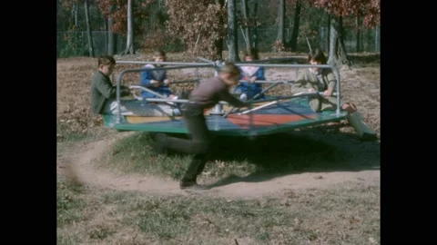 1960s: Playground, children sit, spin, Stock Video Pond5