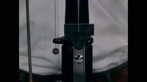 1960s: Pointer on scale moves slightly. Student shifts object holding weight. Stock Footage 169183364