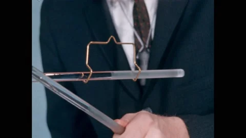 1960s: Probe hanging from string. Hand holding probe. Probe tips touching. Probe Stock Footage 166466641