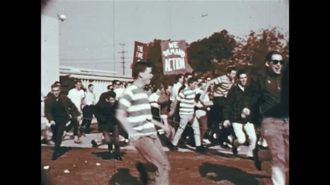 1960s: Protesters start running and attacking a car as a police formation Stock Footage 74491008
