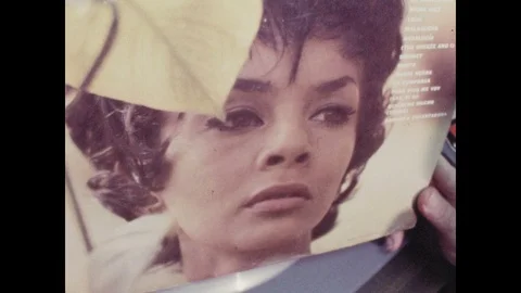 1960s: Record with woman's face. Record spins on player in broadcast studio as Stock Footage 104883772